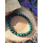 Bracelet Agate Mousse 6 mm bleu-vert sur tranche de bois avec tissu violet en fond, apaisement et douceur du cœur