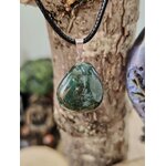 Pendentif agate mousse vert mousse sur cordon noir, photographié devant bois brut et écorce, apaisement mental et respiration intérieure