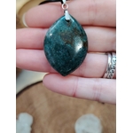 Pendentif agate mousse (goutte) sur cordon noir, gros plan en main ; pierre douce du chakra cœur, aide à relâcher le stress et à retrouver la sérénité.
