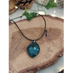 Pendentif agate mousse (goutte) sur cordon noir, sur tranche de bois avec feuillage ; apporte calme et équilibre.