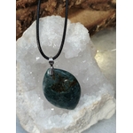 Pendentif agate mousse sur cordon noir, posé sur un amas de quartz; favorise apaisement et harmonie.
