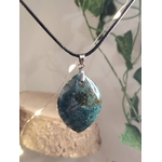 Pendentif en agate mousse (goutte) sur cordon noir, sur fond clair avec feuillage et support bois ; aide à l’apaisement et à la connexion à la nature