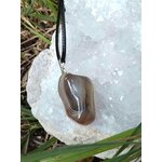 Pendentif agate du Botswana sur druse de quartz blanc dans l’herbe, pierre naturelle pour apaisement émotionnel et relâchement du mental