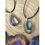 Pendentif agate du Botswana sur cordon noir, présenté sur tissu beige aux tons naturels pour douceur intérieure et stabilité émotionnelle