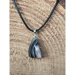 pendentif agate du botswana bandes grises roses en gros plan dans la main, pierre pour apaiser le stress et les émotions