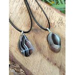 Pendentif agate du Botswana sur planche de bois, harmonie émotionnelle, confort du cœur et sérénité intérieure