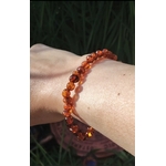 Bracelet ambre naturel couleur miel porté au poignet, perles chaudes et lumineuses pour réconfort intérieur, douceur et énergie solaire