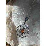 Pendentif Fleur de Vie en argent 925 avec perle d’ambre sur fond bois brut, symbole sacré d’alignement et d’apaisement du mental