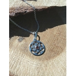 Pendentif Fleur de Vie en argent 925 avec perle d’ambre, suspendu sur une rondelle de bois au décor naturel ; symbole d’harmonie et d’équilibre, associé à la protection énergétique et à une sensation de clarté intérieure (bien-être).