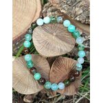 Bracelet chrysoprase posé sur disques de bois avec mousse verte, pierre naturelle pour assurance intérieure et estime de soi apaisée