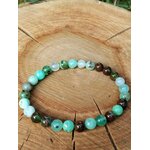 Bracelet chrysoprase posé sur grande tranche de bois fendu, perles vertes et marron pour apaiser les tensions et retrouver la sérénité