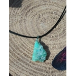Pendentif chrysoprase brute vert d’eau sur cordon noir, posé sur tranche de bois aux cernes marqués, pierre naturelle associée au discernement, au calme des pensées et à la présence à soi.