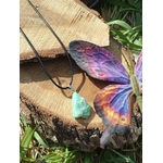 Pendentif chrysoprase naturelle vert d’eau sur cordon noir, décor rondins de bois et herbe, pierre fine verte évoquant la confiance tranquille, l’estime de soi et la fraîcheur émotionnelle.