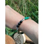 Bracelet Fibromyalgie porté sur fond végétal, pierres naturelles pour stabilité émotionnelle et sensation d’appui intérieur