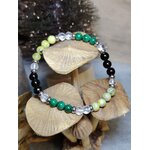 Bracelet Fibromyalgie malachite, serpentine et cristal de roche posé sur rondins, fond sombre, recentrage et stabilité émotionnelle