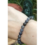 Bracelet iolite en pierre naturelle porté au poignet, perles bleu fumé aux reflets bleutés pour présence calme, ancrage léger et confiance intérieure