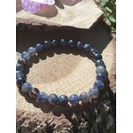 Bracelet iolite sur fond blanc, perles bleu violet et gris bleuté aux reflets indigo pour recul lucide, sérénité émotionnelle et esprit plus net