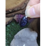 Pendentif iolite ou cordiérite en pierre naturelle, mis en scène avec minéraux clairs et verts, bijou associé à la clarté d’esprit, à l’apaisement et à l’équilibre intérieur.