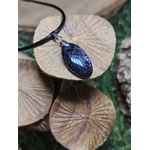 Pendentif iolite ou cordiérite sur cordon noir, posé sur champignons en bois striés, pierre naturelle aux nuances bleu-violet associée à l’écoute de soi, au recul et à la tranquillité intérieure.