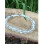 Bracelet cristal de roche 6 mm sur décor bois naturel avec tiges vertes, transparence des perles mise en valeur pour intuition et esprit clair