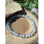 Bracelet cristal de roche 6 mm en cercle sur rondin de bois naturel, perles transparentes polies pour clarté mentale et énergie lumineuse