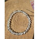 Bracelet cristal de roche 6 mm en cercle sur fond bois chaud, style photo produit pour apaisement mental et sérénité intérieure