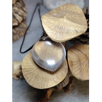 pendentif quartz clair goutte en gros plan sur champignons en bois, transparence mise en valeur — amplification des intentions