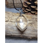pendentif goutte cristal de roche quartz transparent sur cordon noir posé sur bois brut avec pomme de pin en arrière-plan — clarté d’esprit