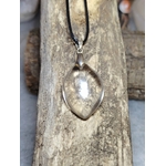 pendentif cristal de roche forme goutte suspendu sur planche bois, reflets discrets, ambiance minimaliste — harmonisation énergétique