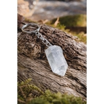 Porte-clés / bijou de sac en cristal de roche taillé en pointe facettée, accroché à un anneau métallique et posé sur une écorce de bois en décor nature, ambiance forêt – Magic Gaïa