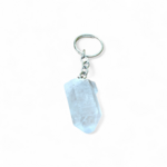 porte-cles-bijou-de-sac-en-cristal-de-roche-taille-en-pointe-facettee-avec-anneau-metallique-pose-sur-fond blanc