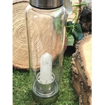 bouteille deau en verre énergisant cristal de roche, vue de côté, bouchon inox, pointe de cristal de roche intégrée, décor tranches de bois et feuillage