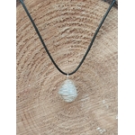 Pendentif cage spirale avec amas de quartz / cristal de roche, sur cordon noir, posé sur tranche de bois — associé à la clarté, l’harmonisation et l’amplification des intentions (symbolique).