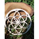 Plateau en bois Graine de Vie 15 cm posé sur une rondelle de bois, décor herbe verte en extérieur, lumière naturelle.