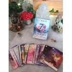 L’Oracle des 7 Énergies – coffret divinatoire en français avec boîte et cartes étalées en éventail, décor nature sur table (champignon décoratif rouge, feuillage, éléments minéraux/pierre blanche) ambiance ésotérique.