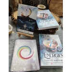L’Oracle des 7 Énergies – coffret divinatoire avec boîtes et cartes visibles, posé sur table en bois dans une ambiance ésotérique, éléments naturels et pierres en décoration.