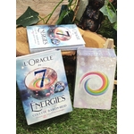 L’Oracle des 7 Énergies – coffret divinatoire en français avec boîte et une carte au motif cercle multicolore, mise en scène sur tapis vert/mousse avec éléments naturels en arrière-plan.