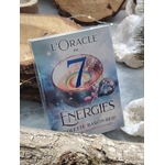 Coffret « L’Oracle des 7 Énergies » (Colette Baron-Reid) posé sur bois naturel, ambiance ésotérique avec pierres claires autour, jeu 49 cartes   livret en français.