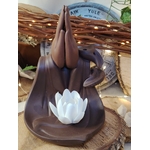 Porte-encens backflow Mains Lotus en terre cuite brun foncé, posé sur rondin de bois rustique, ambiance chaleureuse avec guirlande lumineuse