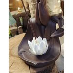 Porte-encens pour cônes backflow Mains Lotus, gros plan sur le lotus blanc, décor bois brut et accessoires spirituels derrière.
