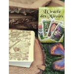 Jeu d’oracle Oracle des miroirs 53 cartes, cartes empilées avec motif doré, coffret visible derrière, ambiance nature sur mousse et rondin de bois.