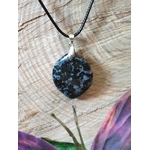 Pendentif indigo gabbro en gros plan sur rondin de bois, pierre naturelle sombre associée à la clarté d’esprit, à l’équilibre émotionnel et à la stabilité profonde.