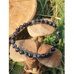 Bracelet Gabbro sur rondins de bois, décor forêt et verdure, bijou lithothérapie associé au recentrage et à la confiance