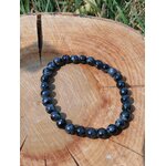 Bracelet Gabbro bleu-noir en cercle sur tranche de bois, décor nature, bijou énergétique pour apaisement mental et recentrage
