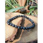 Bracelet Gabbro indigo sur bois naturel, ambiance végétale, pierre d’introspection et de transformation intérieure.