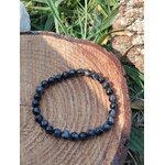 Bracelet perles de Gabbro sur bois naturel avec plantes en fond, bracelet pierre naturelle pour accompagnement du changement