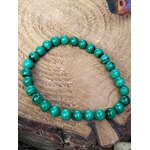 Bracelet en malachite naturelle sur tranche de bois, perles rondes vert marbré, énergie du cœur et équilibre émotionnel.