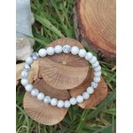 Bracelet howlite blanche 6 mm sur tranche de bois avec fond végétal et décor gravé, perles blanches veinées de gris, patience, stabilité et paix intérieure.