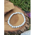Bracelet howlite blanche 6 mm en cercle sur tranche de bois avec herbe, marbrures grises naturelles, détente mentale et endormissement plus serein