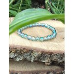 Bracelet Aqua Aura sur bois texturé, quartz bleu irisé aux reflets changeants, paix intérieure, ouverture intuitive et douceur vibratoire